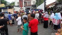 Warga yang penasaran mengintip dari luar gerbang.