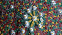 Detail lantai di rumah plastik Maria. Ia menggunakan tutup botol dengan beragam ukuran untuk dijadikan lantai rumahnya.