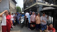 Warga rela berpanas-panasan untuk melihat tersangka pembunuhan.