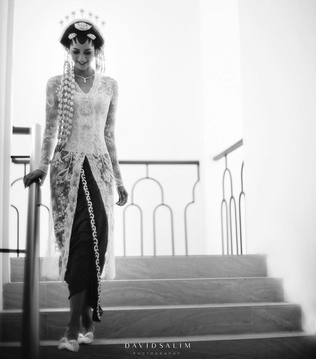 Paula Verhoeven tampil mengenakan kebaya karya desainer Biyan Wanaatmadja dalam akad nikahnya dengan Baim Wong di gedung Tribrata Dharmawangsa, Jakarta Selatan. Dalam foto karya David Salim yang diunggahnya ke akun Instagramnya, Paula terlihat anggun menjadi pengantin Jawa dibalut kebaya putih dari Biyan. Foto: Dok. David Salim Photography