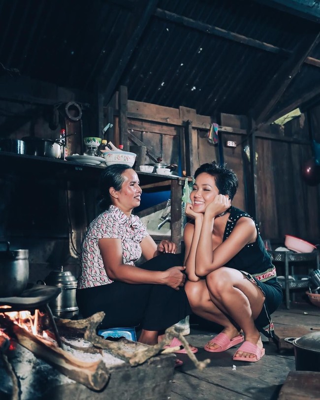 Baru-baru ini sosok HHen Nie kembali menjadi buah bibir karena unggahan fotonya di Instagram. Dia mengunggah kebersamannya dengan sang ibu di rumah mereka yang begitu sederhana. Tampak rumah HHen Nie terbuat dari kayu yang pada beberapa bagian sudah tampak menghitam. Area dapur rumahnya belum ada sentuhan modernitas. Miss Universe Vietnam 2017 itu pun tampak berjongkok di dekat ibunya yang duduk di atas jengkok (tempat duduk kecil). Foto: Dok. Instagram HHen Nie