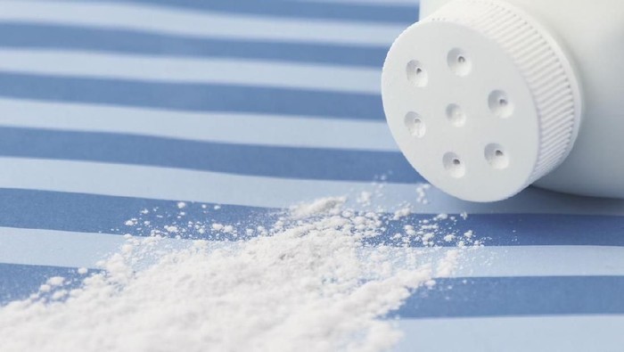 ilustrasi bedak bayi Spilled baby scented powder on striped background with short depth of field