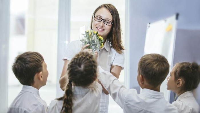 Beautiful children school children with flowers for the teachers at school on a holiday