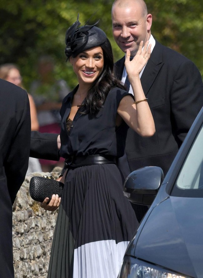 Ketika menghadiri pernikahan sahabat Pangeran Harry, Charlie Van Straubenzee dan Daisy Jenks, kancing kemeja hitam Meghan terbuka dan memperlihatkan bra lace di baliknya. Foto: Ist.
