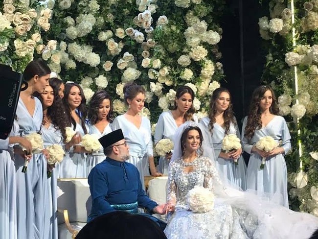 Dalam pesta pernikahan tersebut kedua mempelai tampil tidak seragam seperti pengantin pada umumnya. Yang di-Pertuan Agong Sultan Muhammad V mengenakan busana khas Melayu berwarna biru lengkap dengan sarun songketnya. Sedangkan Oksana Voevodina mengenakan gaun pengantin internasional berwarna putih yang megah. Foto: Dok. Facebook/Islamnews