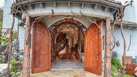 Pilar rumah ini didesain seperti menggunakan kayu tua lengkap dengan cabang dan rantingnya. Pintunya pun dibuat ukiran-ukiran seperti dalam film fantasi. Istimewa/Boredpanda.