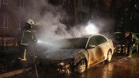 Tampak sebuah mobil yang parkir di depan Kedubes Rusia dibakar pendemo. REUTERS/Serhii Nuzhnenko.