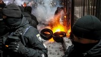 Sejumlah warga Ukraina berdemo di depan Kedubes Rusia di Kiev. Mereka membakar ban, Minggu (25/11) waktu setempat. REUTERS/Gleb Garanich.