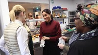 Mengenakan outfit kasual warna burgundy, Meghan terlihat tengah bersiap terjun ke dapur. Ia mengenakan hand glove sebelum mulai meracik makanan. Foto: Istimewa/Independent