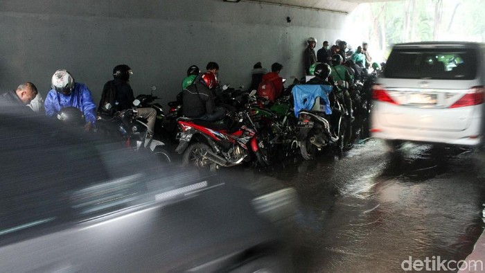 Hujan mengguyur kawasan ibu kota, Senin (26/11/2018). Para pengendara sepeda motor memilih tidak melanjutkan perjalanan dengan berteduh di kolong Semanggi.