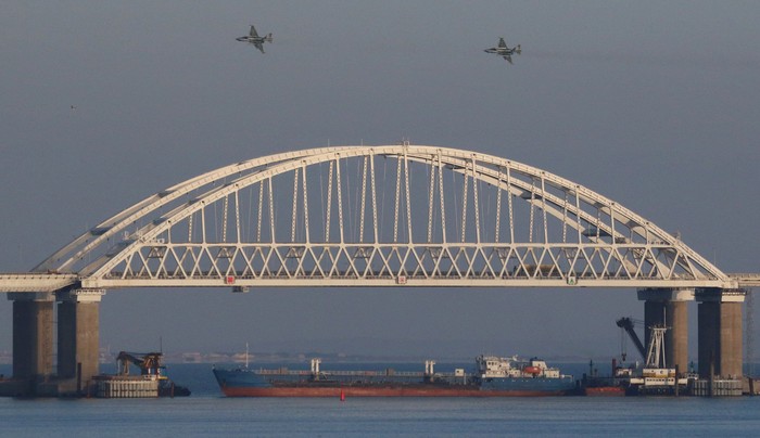 Russian jet fighters fly over a bridge connecting the Russian mainland with the Crimean Peninsula with a cargo ship beneath it after three Ukrainian navy vessels were stopped by Russia from entering the Sea of Azov via the Kerch Strait in the Black Sea, Crimea November 25, 2018. REUTERS/Pavel Rebrov     TPX IMAGES OF THE DAY