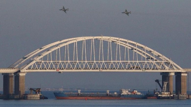 Russian jet fighters fly over a bridge connecting the Russian mainland with the Crimean Peninsula with a cargo ship beneath it after three Ukrainian navy vessels were stopped by Russia from entering the Sea of Azov via the Kerch Strait in the Black Sea, Crimea November 25, 2018. REUTERS/Pavel Rebrov     TPX IMAGES OF THE DAY
