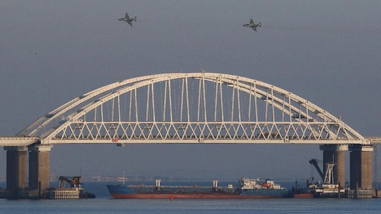 Jet-jet tempur Rusia terbang di atas jembatan yang menghubungkan daratan utara Rusia dengan Krimea setelah tiga kapal militer Ukraina disita Russian jet fighters fly over a bridge connecting the Russian mainland with the Crimean Peninsula with a cargo ship beneath it after three Ukrainian navy vessels were stopped by Russia from entering the Sea of Azov via the Kerch Strait in the Black Sea, Crimea November 25, 2018. REUTERS/Pavel Rebrov TPX IMAGES OF THE DAY