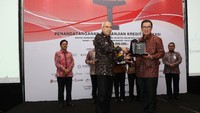 Direktur Kredit Bank Mega, Madi Darmadi Lazuardi (kanan) menerima plakat dari Direktur Utama JTD, Frans Sunito (kiri) di sela-sela penandatanganan perjanjian kredit investasi sindikasi senilai Rp. 13,7 triliun. Istimewa/Bank Mega.