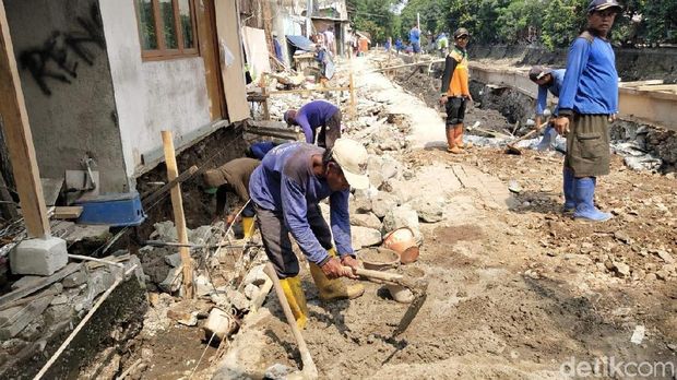 Petugas sedang membuat fondasi, saluran air, dan perbaikan turap