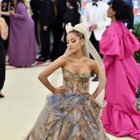Ariana Grande menghadiri Met Gala di 2018. Ia tampil heboh dengan ballgown bermotif lukisan dan hair piece pita raksasa. (Foto: Getty Images)