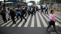 Setelah menekan tombol dan lampu menyala merah, warga mulai menyeberang di jalan tersebut.
