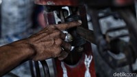 Seorang pengepul tengah menimbang sampah plastik.