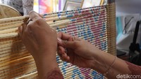 Proses pembuatan motif ini disebut medbed. Caranya dilakukan dengan mengikatkan tali rafia untuk menyusun motif. Semakin rumit motif, harga kainnya semakin mahal (Ditya/detikTravel)  