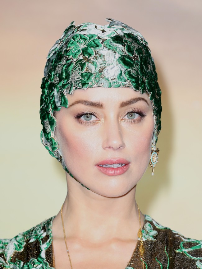 Padanan untuk gaun couturenya, Amber Heard memilih topi renang bernuansa hijau dengan ornamen bunga. Mengingatkan akan gaya ballerina air di tahun 50-an, yang sesuai dengan tema film ini. Foto: Dok. Getty Images