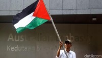 Massa aksi pun membawa serta bendera Palestina dalam aksi unjuk rasa tersebut.