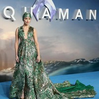 Amber tampil memukau memakai gaun plunging hijau keemasan dari Valentino. Kalung emas panjang dan stiletto metalik melengkapi penampilannya. Foto: Dok. Getty Images