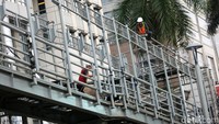 Para pekerja merevitalisasi jembatan penyeberangan orang (JPO) Gelora Bung Karno, Senayan, Jakarta, Selasa (27/11/2018).