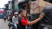 Mereka mengikat beragam barang diatas mobil bajaj dengan menggunakan tali untuk menjaga agar barang-barang itu tidak jatuh saat diangkut.