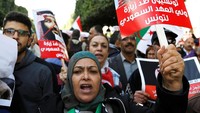 Para demonstran juga membawa poster berukuran besar yang menunjukkan Presiden Tunisia sedang menuangkan air ke atas tangan MBS yang berlumuran darah, yang mengindikasikan Tunisa membantu Saudi mencuci tangan dalam kasus Khashoggi. Foto: REUTERS/Zoubeir Souissi