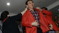 Djarot Saiful Hidayat yang baru saja melempar isu Ahok bakal gabung PDIP, kala itu turut merapihkan jas merah yang pas dipakai Ahok.