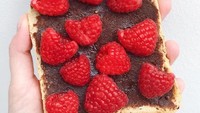 Buat yang ingin tambah asupan buah, cukup tambahkan raspberry atau strawberry di atas olesan cokelat. Rasanya asam manis, segar! Foto: Instagram @sophieshealthykitchen