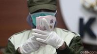 Petugas KPK menunjukkan barang bukti uang pecahan dolar Singapura yang diamakan dalam OTT.