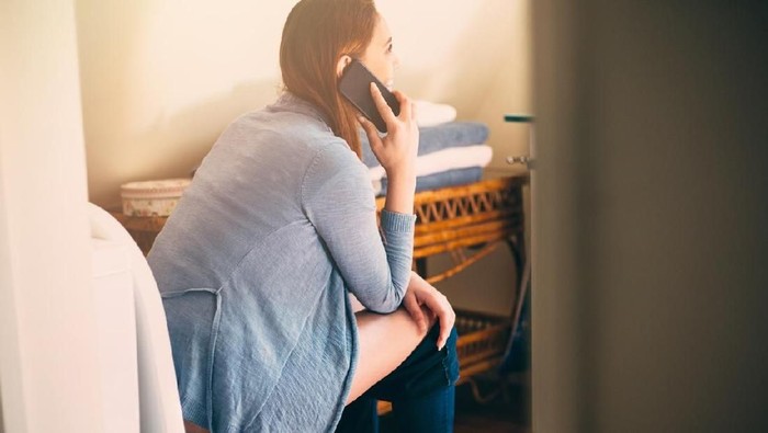 Ilustrasi menggunakan handphone di toilet. Foto: iStock Ilustrasi menggunakan handphone di toilet. Foto: iStock