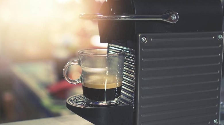 173655712 coffee machine makes two coffee with coffee beans on background