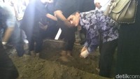 Zumi Zola menangis saat menggali kuburan sang ayah. Zumi tetap dikawal petugas KPK saat prosesi pemakaman. (Ferdi-detik)