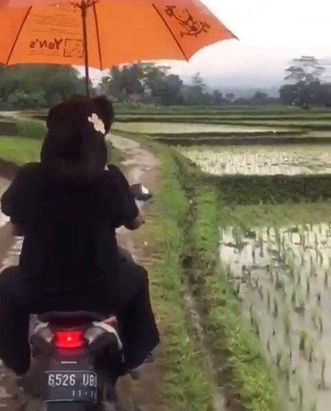 Anne Avantie membagikan kisah perjalanannya bertemu desainer difabel yang viral, Rahmat Hidayat, di Instagram. Desainer langganan selebriti kondang Tanah Air itu terlihat naik ojek sembari berpayungan dan melewati sawah. Ketika itu, awan mendung menggantung diiringi hujan rintik-rintik. Foto: Instagram Anne Avantie