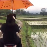 Anne Avantie membagikan kisah perjalanannya bertemu desainer difabel yang viral, Rahmat Hidayat, di Instagram. Desainer langganan selebriti kondang Tanah Air itu terlihat naik ojek sembari berpayungan dan melewati sawah. Ketika itu, awan mendung menggantung diiringi hujan rintik-rintik. Foto: Instagram Anne Avantie