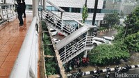 Banyaknya pemotor yang berteduh, bahkan sampai memenuhi tangga JPO.