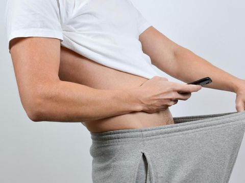 Man taking a picture of his penis with a smart-phone. A so-called dick pic