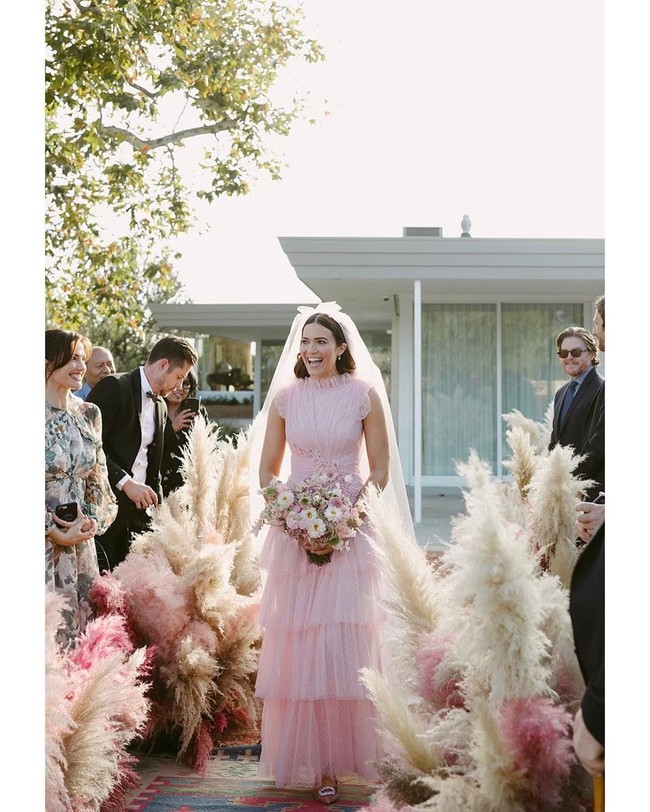 Karakter Mandy yang manis terlihat lewat pilihan gaun ruffle Rodarte. Hand bouquet bernuansa pink di tangan menyempurnakan penampilannya. Foto: Dok. Instagram @mandymooremm