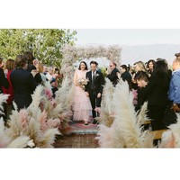 Langkah Mandy menuju altar dihiasi rangkaian rumput pampas menjulang tinggi, juga dihiasi gradasi bunga warna pink yang cantik. Foto: Dok. Instagram @mandymooremm