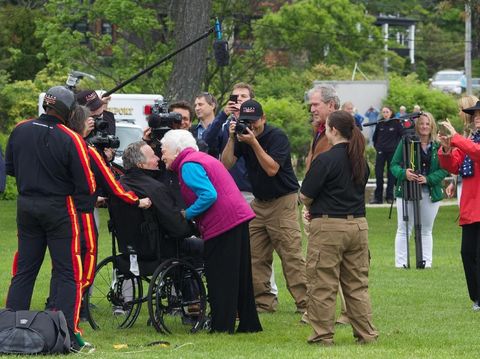 George HW Bush disambut istri, Barbara Bush, setelah terjun payung untuk merayakan ultah ke-90.