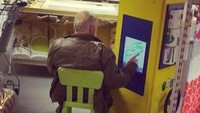 Sambil menunggu, pria ini justru menggambar di mesin mainan yang tersedia di area belanja. Istimewa/Boredpanda.