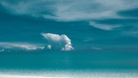 Pasir putih, laut dan langit biru serta kelapa muda. Duh pose Harival ini seperti sedang ada di pantai pribadi ya. Foto: Instagram @harivalzayuka