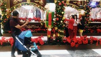 Pengunjung menikmati ornamen nuansa Natal di Lippo Mall Puri, Jakarta.