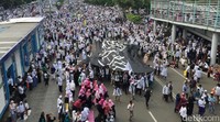 Massa mengarak bendera tauhid menuju Monas.
