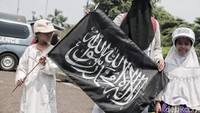 Seorang peserta mengajak anaknya untuk menghadiri Reuni 212.