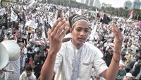 Salah satu peserta berdoa di depan massa yang memadati Monas.