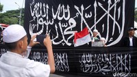 Beberapa peserta foto bersama di depan spanduk bertuliskan kalimat tauhid.