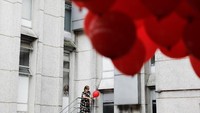 Seorang perempuan di Emilio Ribas Hospital, Sao Paulo, Brazil, memegang balon merah sebelum dilepaskan. Balon merah merupakan simbol Hari Aids Sedunia. (REUTERS/Nacho Doce) 